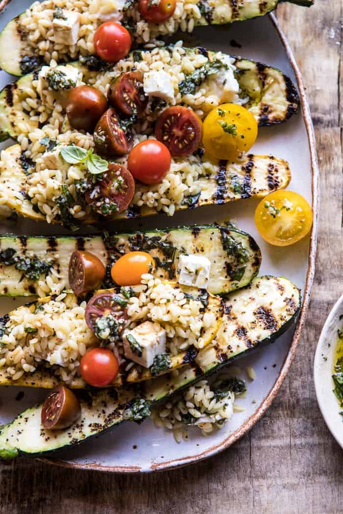close up photo of side angled Grilled Pesto Zucchini Stuffed with Tomatoes and Orzo