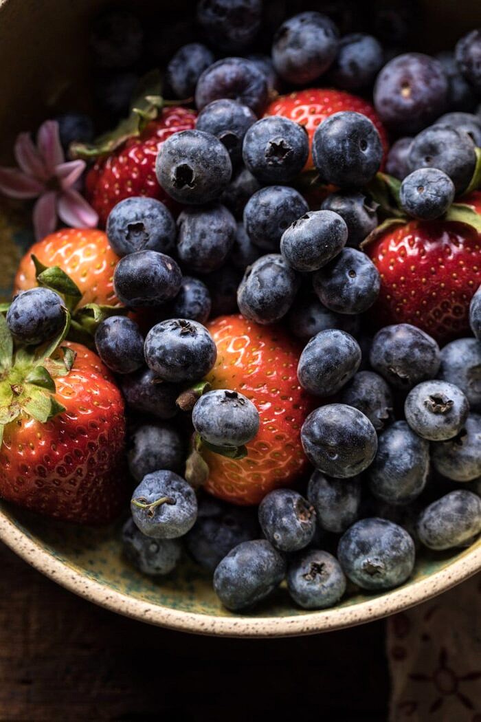 close up overhead photo of strawberries and blueberries 