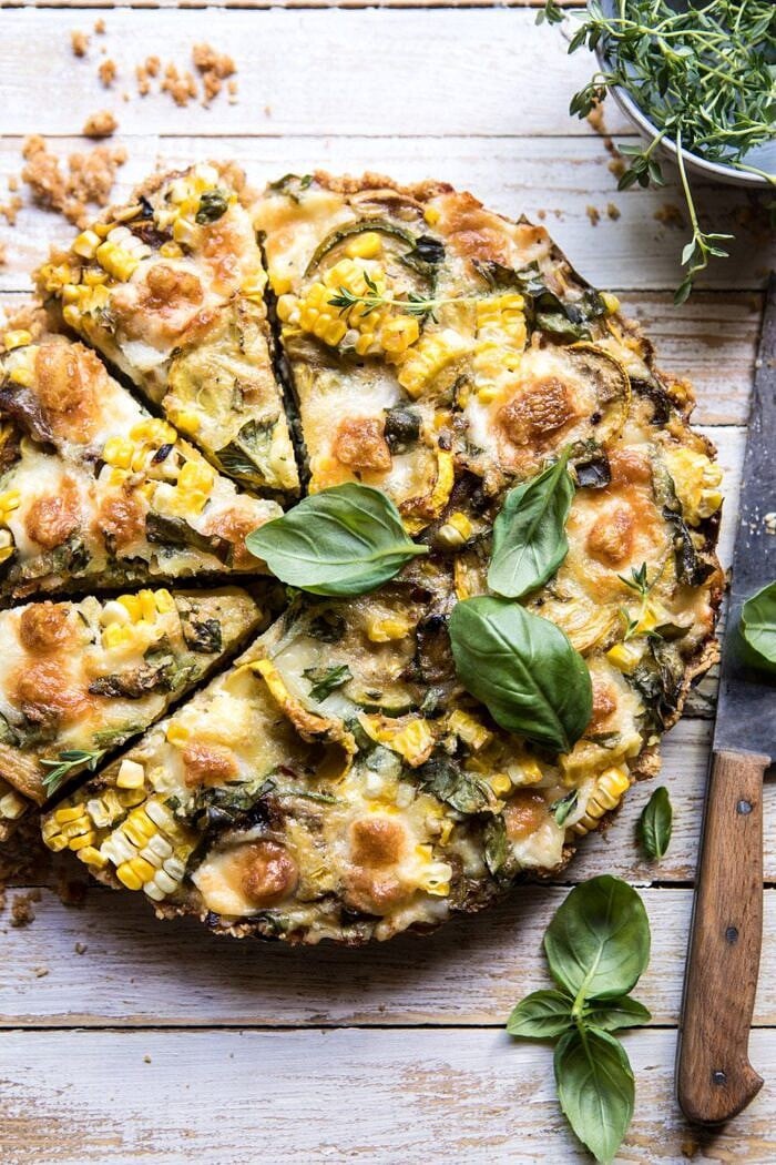 overhead photo of Cheesy Zucchini and Corn Pie with 3 pieces cut and a knife