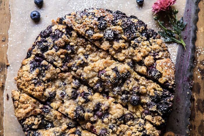 overhead photo of Bursting Blueberry Cardamom Buckle with knife in photo