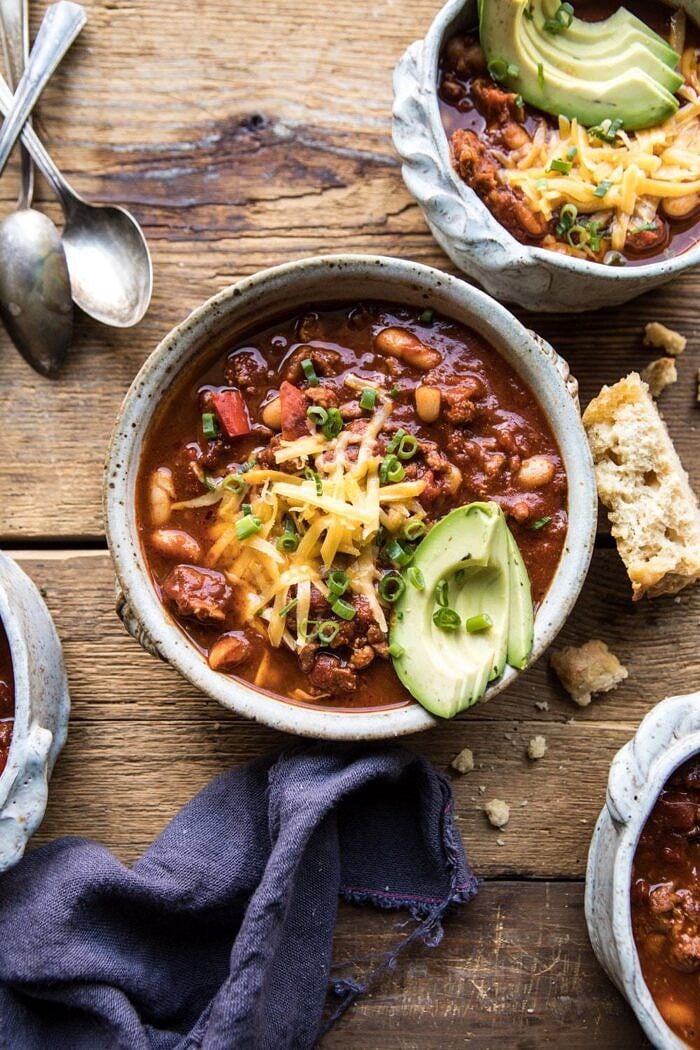 overhead photo of Healthy Slow Cooker Turkey and White Bean Chili with beer bread and spoons in photo