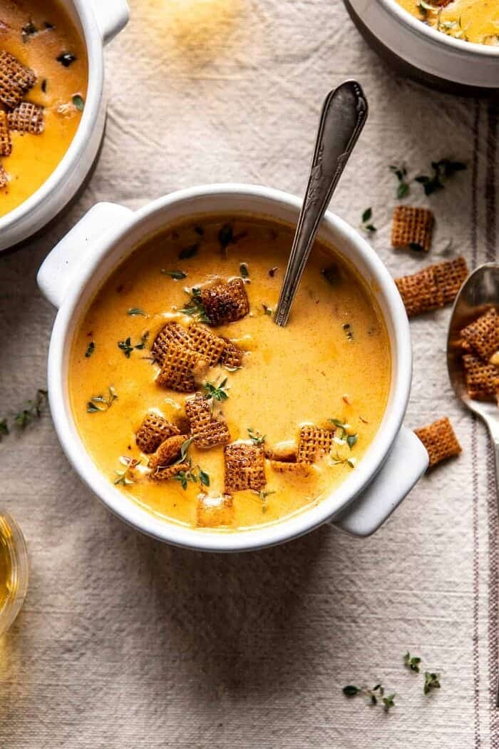 overhead photo of Beer Cheese Soup with Chili Spiced Chex with spoon in bowl