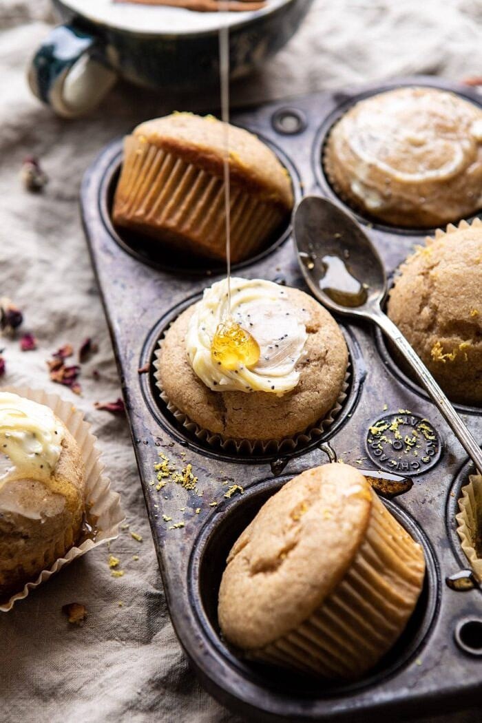 side angle photo of Vanilla Chai Lemon Ricotta Muffins with honey being drizzled on