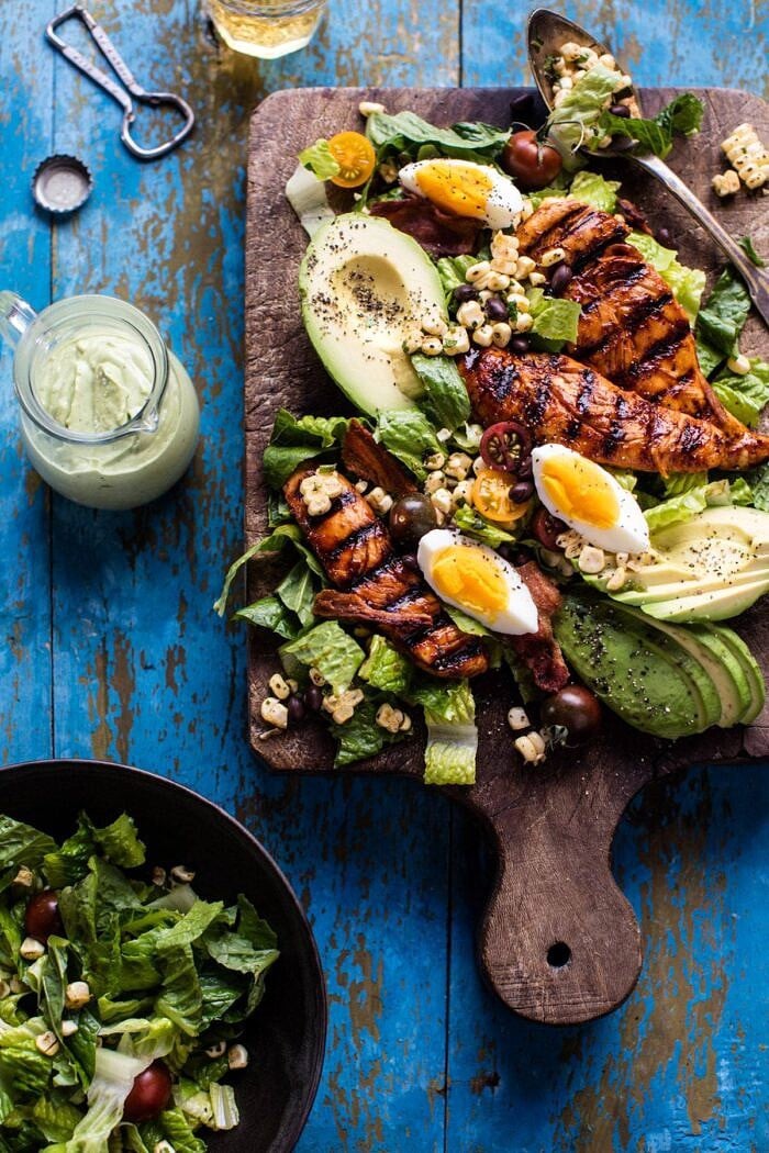 overhead photo of BBQ Chicken Cobb Salad with Avocado Ranch with salad on cutting board