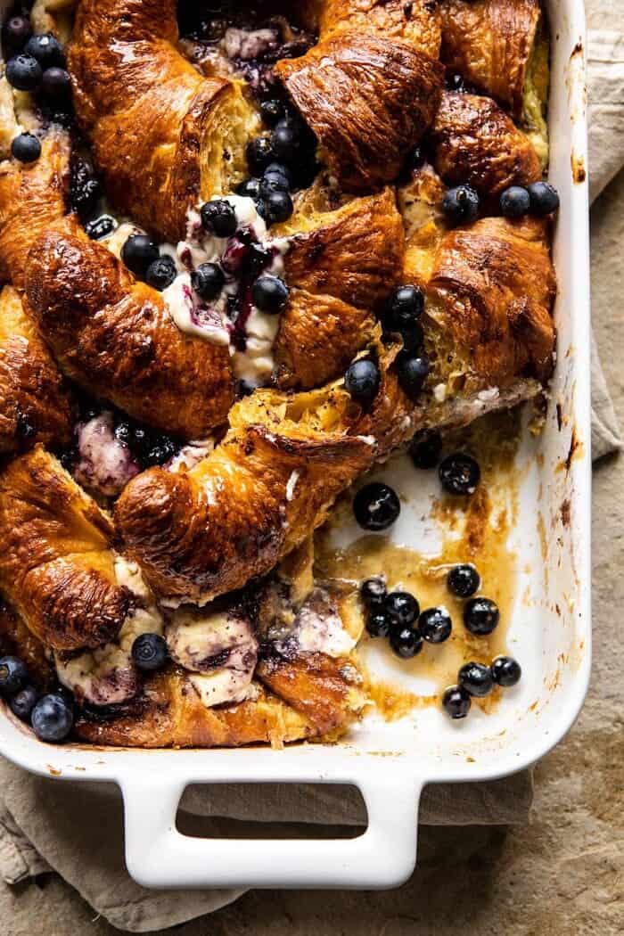 overhead photo of Berry and Cream Cheese Croissant French Toast Bake with serving piece taken out