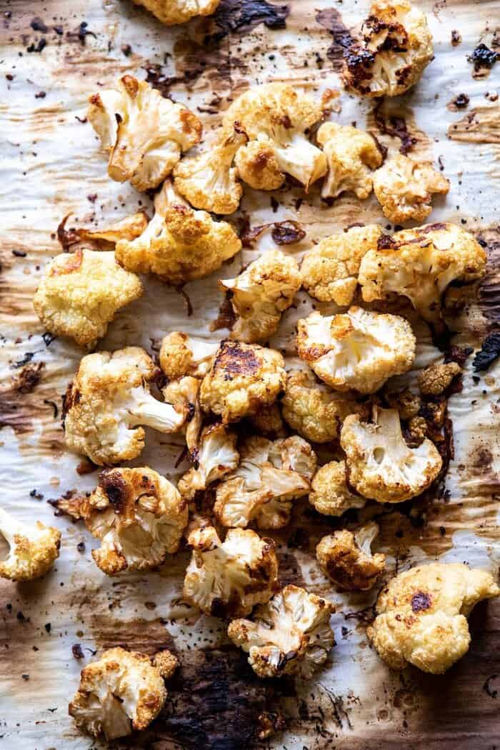 roasted cauliflower on baking sheet before tossing with sauce 