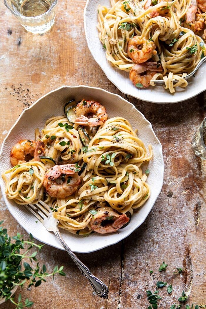 overhead photo of Garden Herb Shrimp Scampi Linguine with fork in bowl and herbs on table