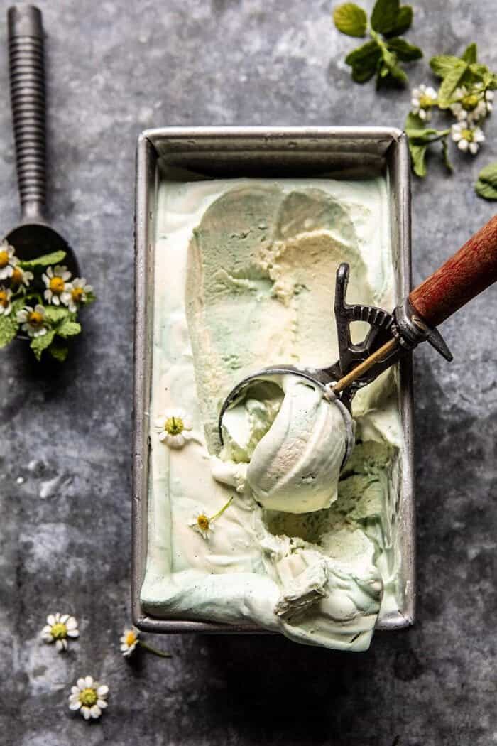 overhead photo of No Churn Minted White Chocolate Swirled Ice Cream with ice cream scoop in ice cream 