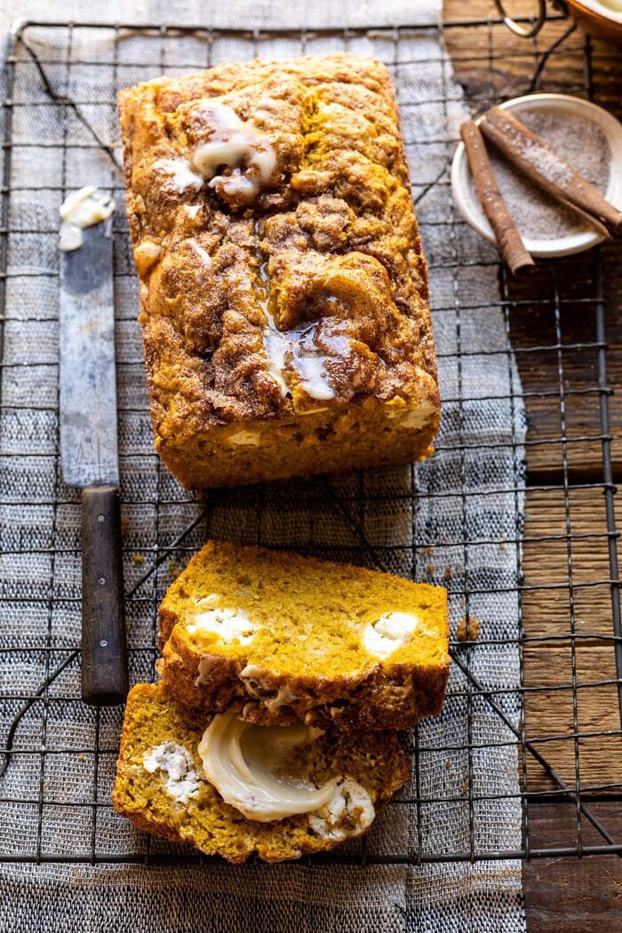 overhead photo of Cream Cheese Swirled Pumpkin Bread with 2 slices of bread cut and cinnamon sugar in photo