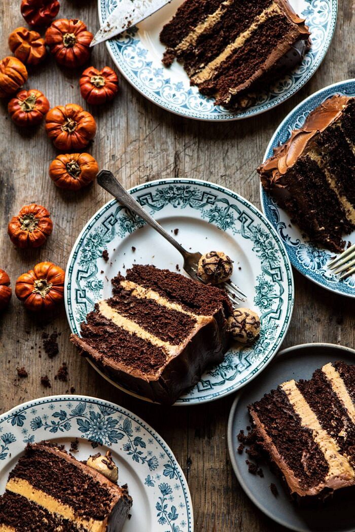 overhead photo of Pumpkin Patch Chocolate Peanut Butter Cake slices on plates with mini pumpkins on table
