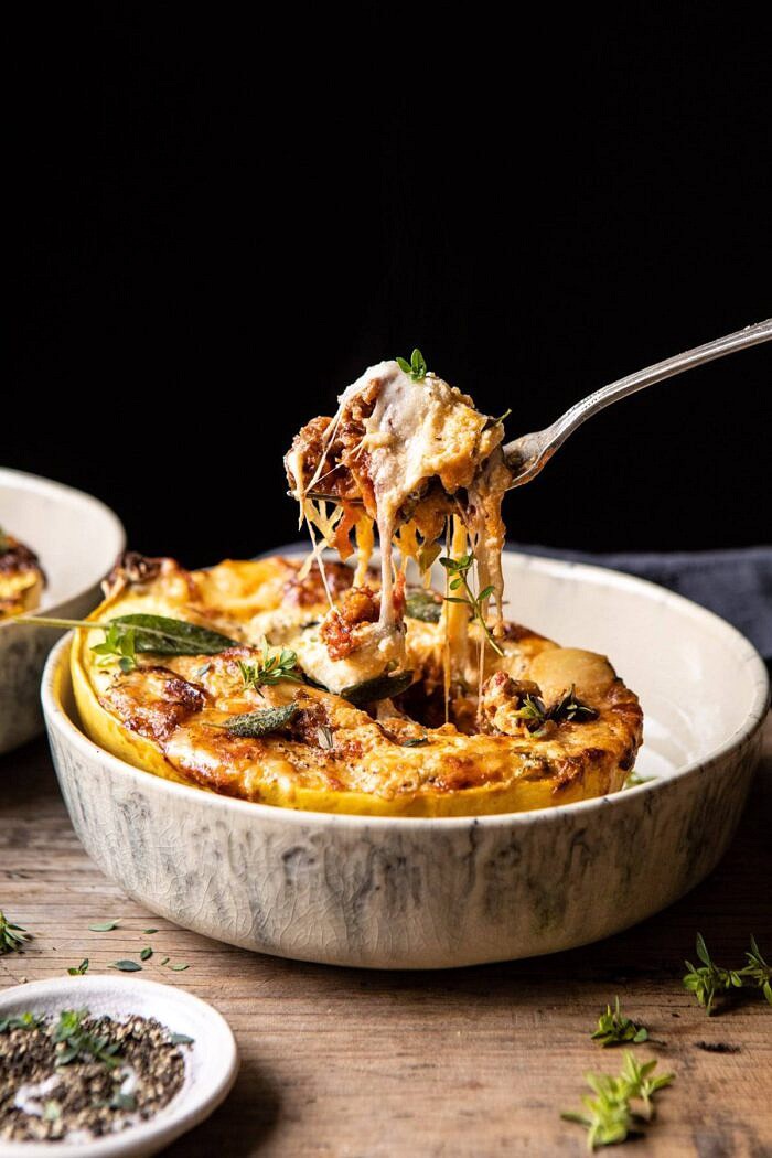 side angled photo of Roasted Garlic Spaghetti Squash Lasagna Boats with fork pulling up a bite of the spaghetti squash and cheese