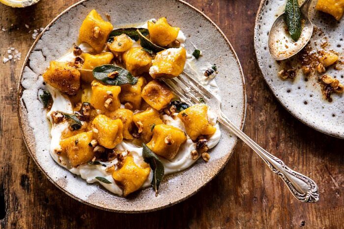 horizontal photo of Pumpkin Cauliflower Gnocchi with Nutty Browned Butter and Whipped Ricotta and fork in bowl 