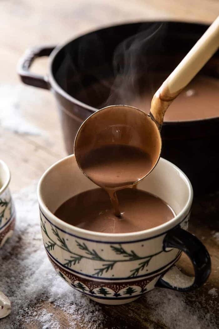Creamy Coconut Hot Chocolate being poured into hot cocoa mug