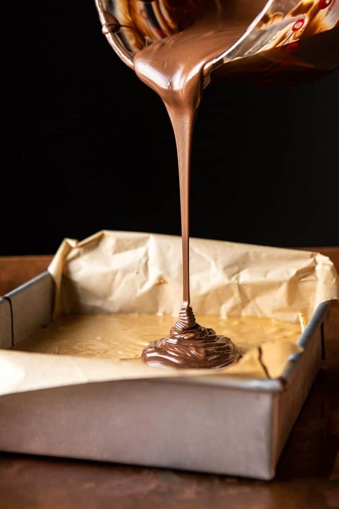 side angled photo of 5chocolate being poured over top bars