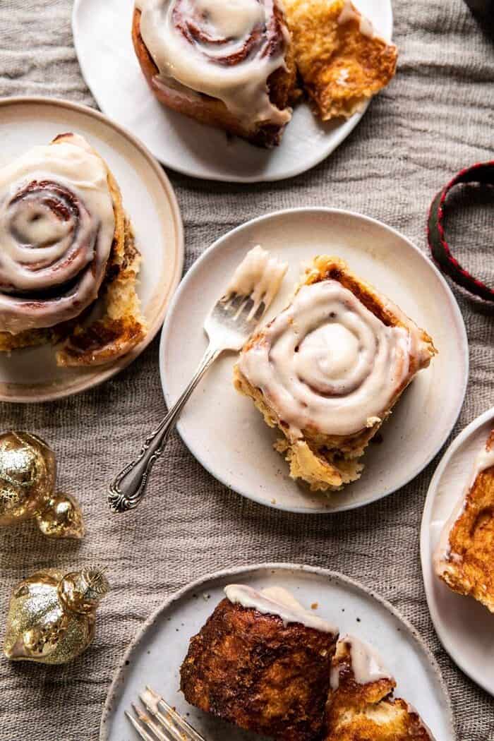 overhead photo of Easy Gingerbread Brioche Cinnamon Rolls on plates with forks 