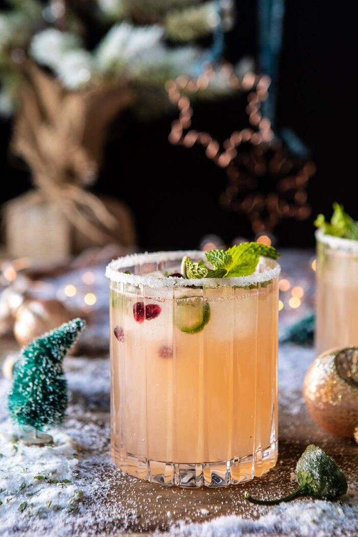 side angle photo of The Spicy Sweet Grinch Cocktail with christmas tree in the background