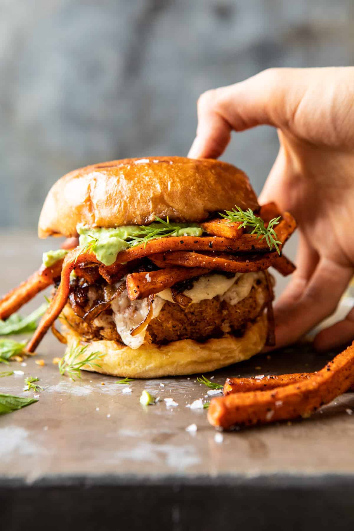 Crispy Quinoa Burgers Topped with Sweet Potato Fries and Beer Caramelized Onions | halfbakedharvest.com #quinoaburger
