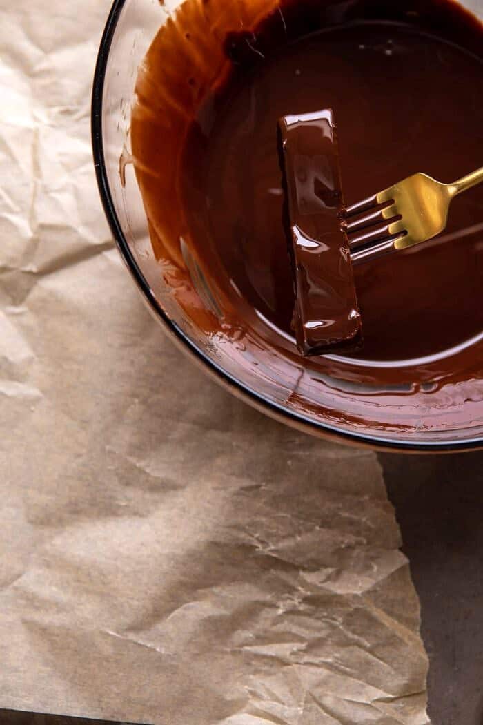 dipping the Twix bars in melted chocolate