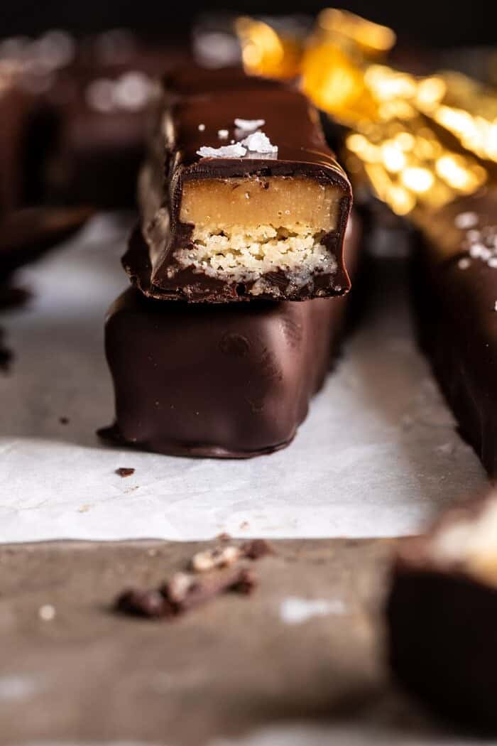 side angled photo of Homemade Vegan Twix Bars with 1 bar cut in half to expose the filling