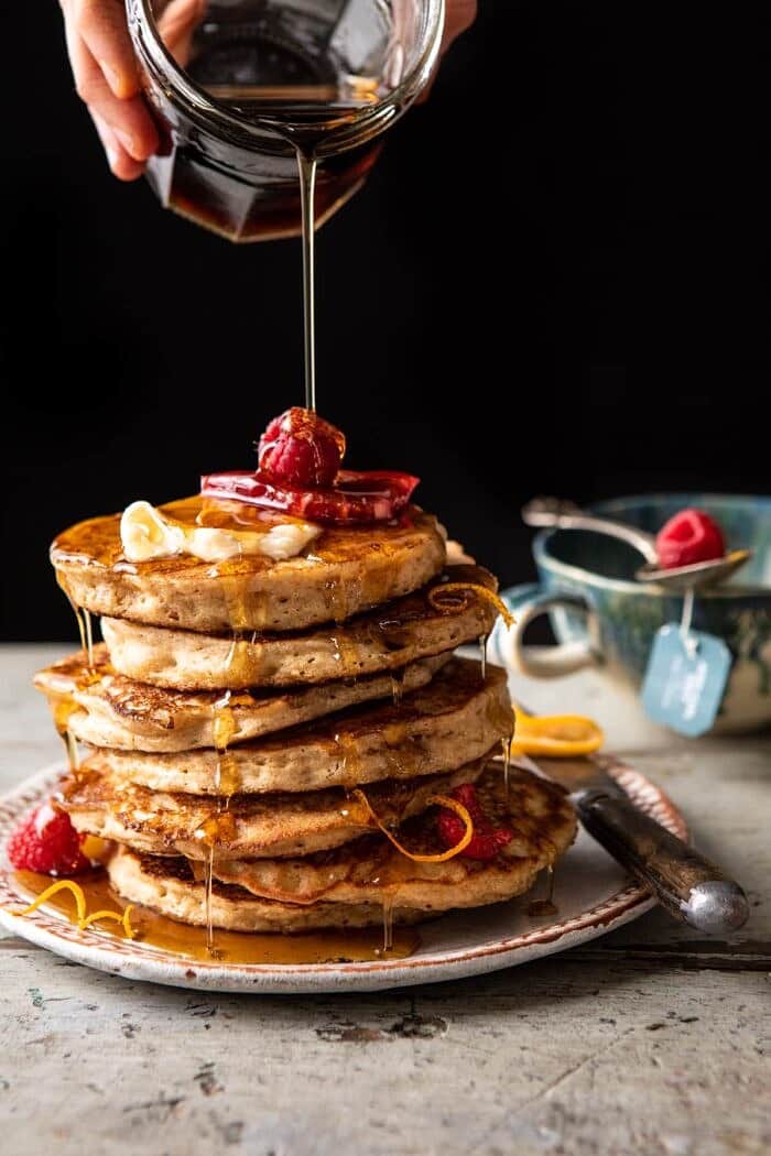 Earl Grey Lemon Ricotta Pancakes with Salted Maple Butter and maple syrup being poured over pancakes
