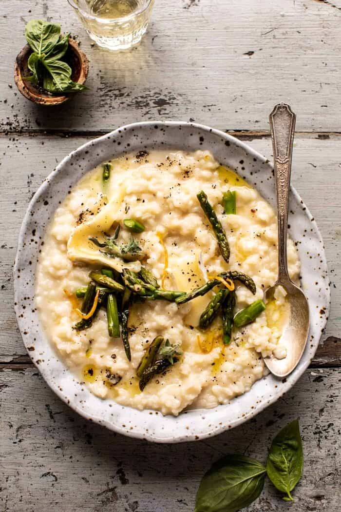 overhead photo of No Stir Brie Risotto with Lemon Butter Asparagus and spoon placed in the bowl with risotto 