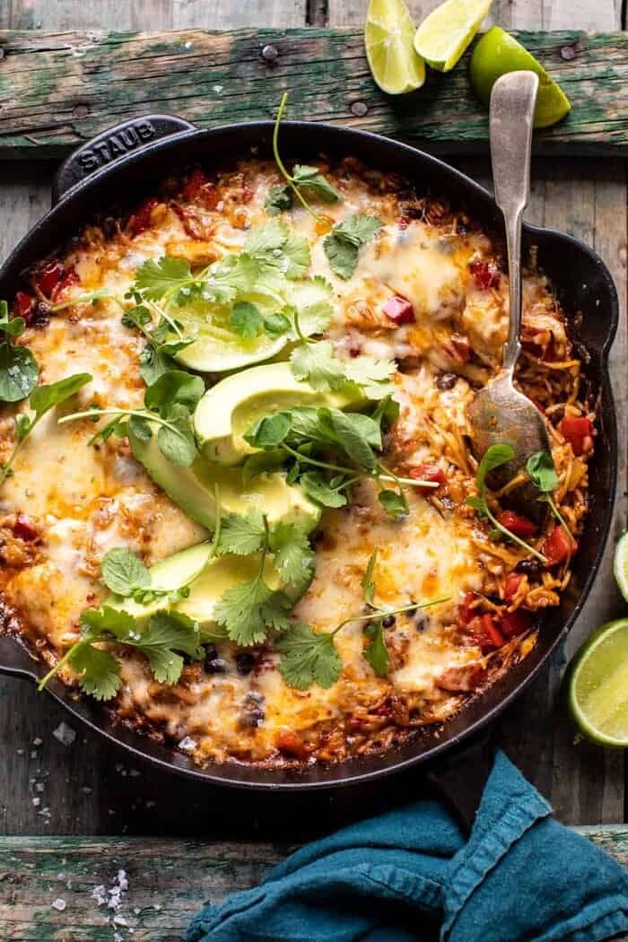 Overhead photo of One Skillet Cheesy Cuban Chicken Rice Bake with spoon in rice