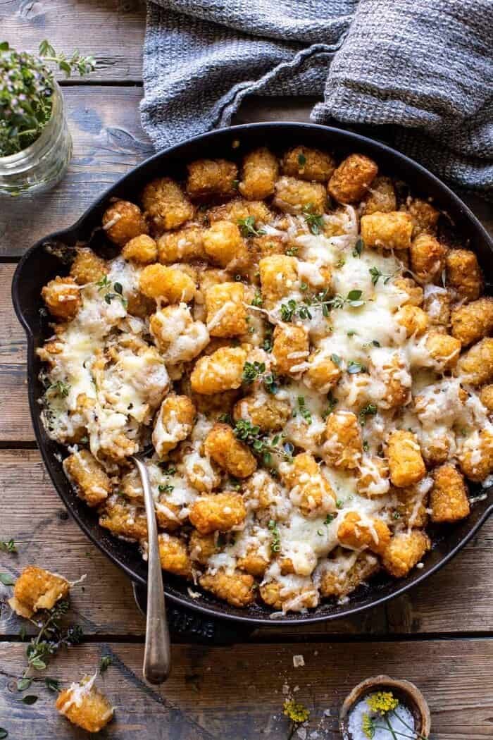 overhead photo of One Skillet French Onion Tater Tot Casserole with spoon in skillet 