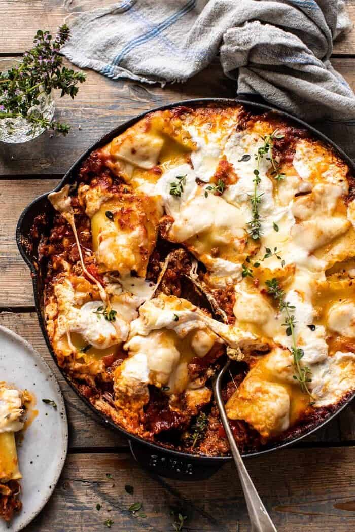 overhead photo of Simple Skillet Pesto Cheese Lasagna Roll Ups with serving spoon in skillet