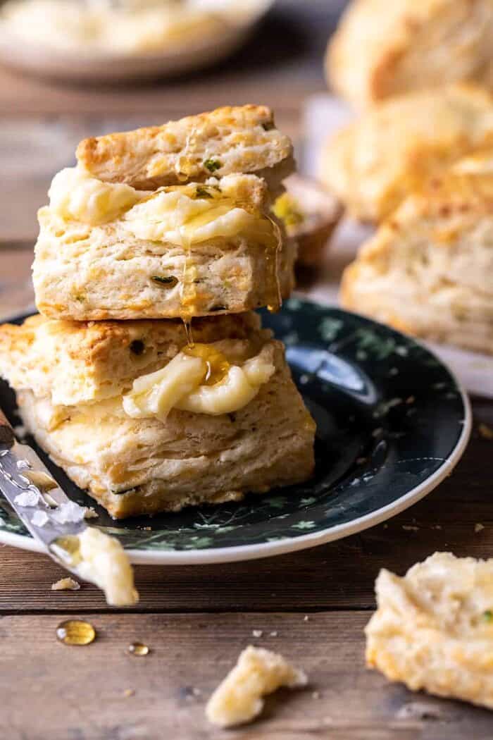 side angled photo of Layered Jalapeño Cheddar Biscuits with 2 biscuits stacked on top of each other and with Salted Honey Butter