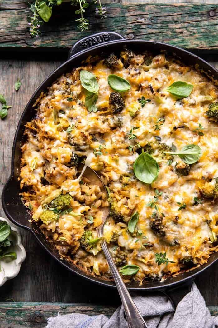 overhead photo of One Skillet Cheesy Broccoli Cheddar Orzo Bake with spoon in skillet 