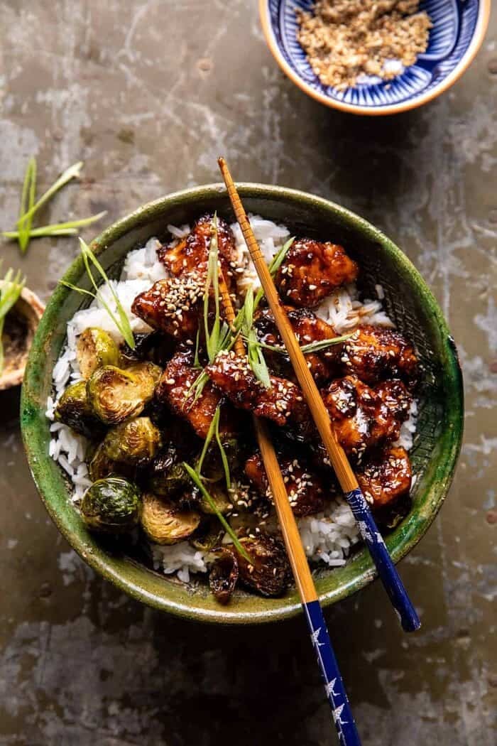 overhead photo of Sheet Pan Sticky Ginger Sesame Chicken and Crispy Brussels Sprouts and chopsticks in bowl 