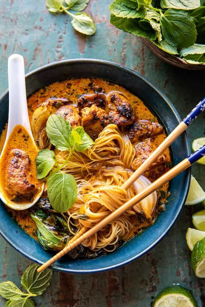 overhead photo of 30 Minute Creamy Thai Turmeric Chicken and Noodles with noodles in chopsticks