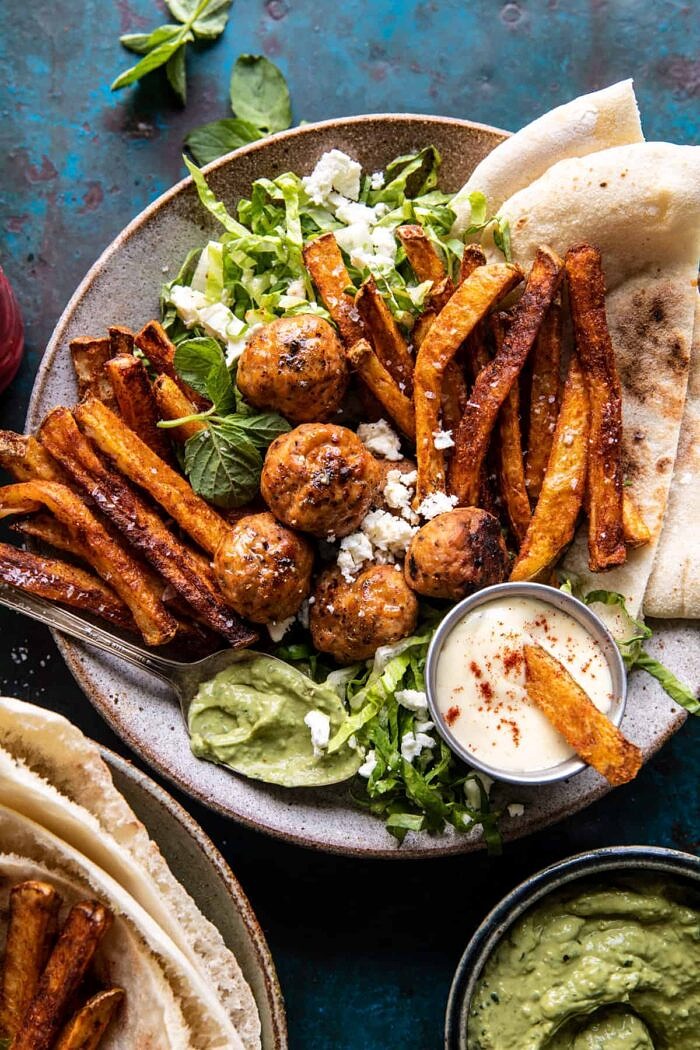 overhead photo of Chicken Meatball Pita Bowls with Seasoned Fries and Feta