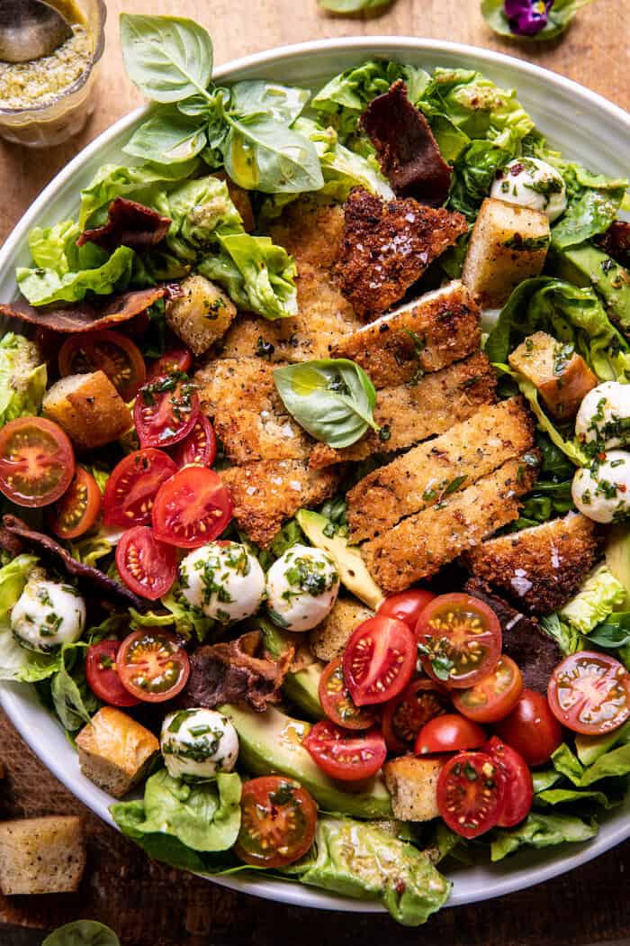 overhead close up photo of Crispy Italian Chicken and Bacon Salad with Tahini Pesto Dressing and Sourdough Croutons