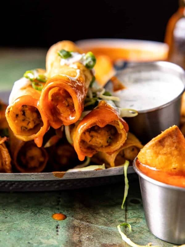 taquitos stacked with buffalo sauce dripping off