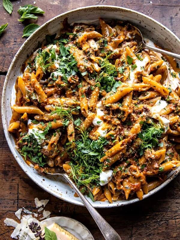 overhead photo of sun-dried tomato pasta in serving bowl with parmesan on table