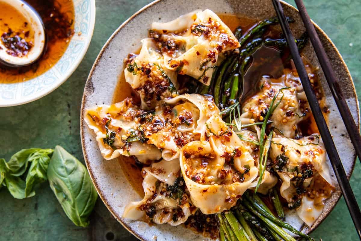 wontons in a bowl with chili oil and asparagus 
