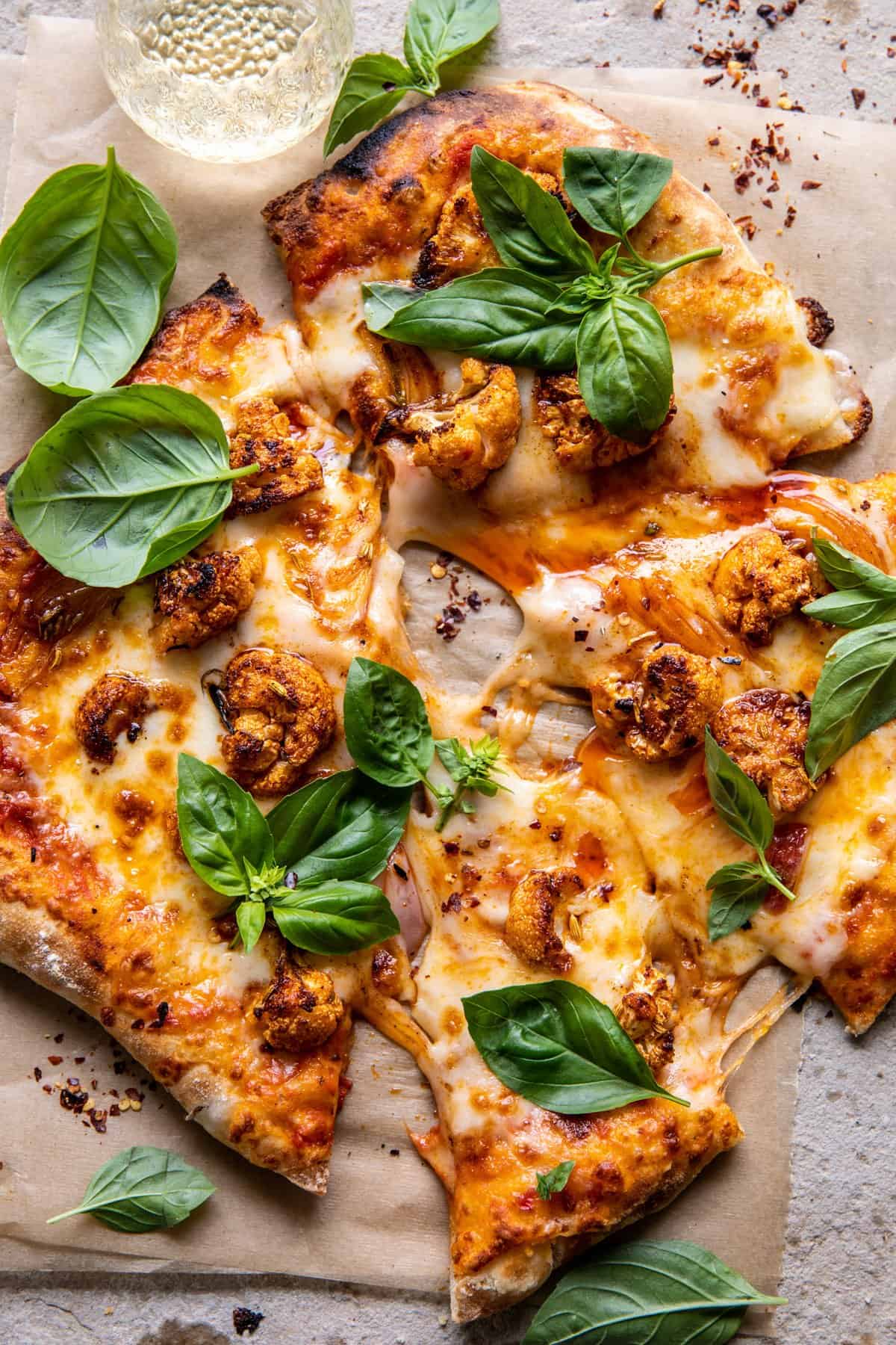Cauliflower Pepperoni Cheese Pizza  with large slices cute from pizza and wine in glas 
